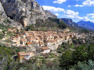 a small town in the mountains with houses at BABILOC Industriel Appartement in Riez
