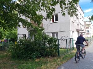 a man riding a bike down a street at Apartament Kraszewskiego - Retro, blisko Starówki, koło parku, ogród dla gości, rowery free in Toruń