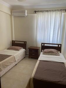 1 dormitorio con 2 camas, mesa y ventana en Royal Marina, en Didim