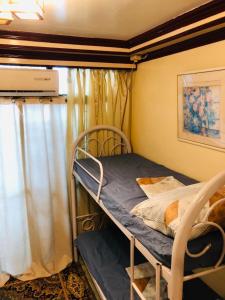 Ce lit superposé se trouve dans un dortoir doté d'une fenêtre. dans l'établissement THE MANSION - BACKPACKERS Near AIRPORT, à Manille