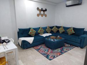 a living room with a blue couch and a rug at Studio Superbe Parc Mohammedia in Mohammedia
