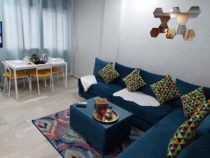 a living room with a blue couch and a table at Studio Superbe Parc Mohammedia in Mohammedia