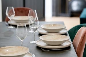 a table with plates and wine glasses on it at L'Arty - Très joli studio moderne place Valmy in Lyon