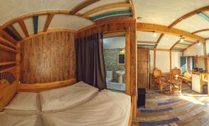 um quarto com uma cama num quarto com paredes de madeira em Cozy House em Dilijan