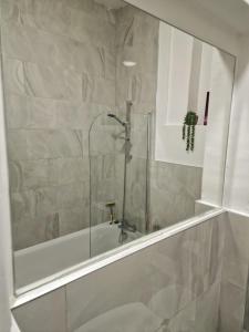 bagno con doccia, vasca e lavandino di Spacious 4 Bedroom apartment in amazing location a Londra