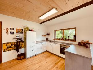 a kitchen with white appliances and a wooden ceiling at Beim Baltas in Wildpoldsried
