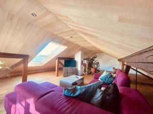 a living room with a purple couch in an attic at Beim Baltas in Wildpoldsried