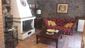 a living room with a red couch and a fireplace at Il Fico di Cortona in Cortona