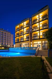 a building with a swimming pool at night at Rex Residence Hotel in Cattolica