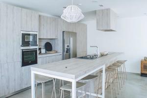 una cocina con una gran mesa blanca y sillas en Can Romina - Santa Eulalia, en Santa Eulària des Riu