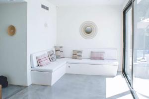 Habitación blanca con sofá blanco con almohadas en Can Romina - Santa Eulalia, en Santa Eulària des Riu
