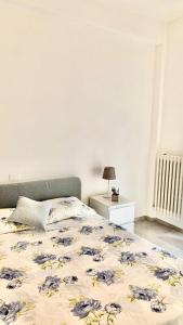 - une chambre dotée d'un lit avec un couvre-lit floral dans l'établissement Affittacamere Roberta, à Osimo