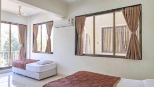 1 dormitorio con 2 camas y ventana en DREAM HOLIDAYS RESORT, en Lonavala