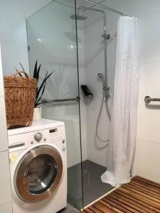 y baño con lavadora y ducha acristalada. en Cook's Cottage in Balhannah, en Balhannah
