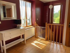 Habitación con un pasillo con escalera y ventanas. en Le moulin Bertrand, en Martigny-Courpierre