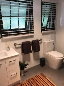 ein Badezimmer mit einem weißen WC und schwarzen Handtüchern in der Unterkunft Cook's Cottage in Balhannah in Balhannah