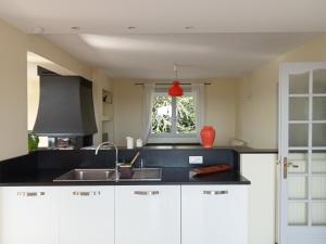 a kitchen with white cabinets and a sink and a window at Vaste villa en position dominante superbe vue lacs in Hautecour