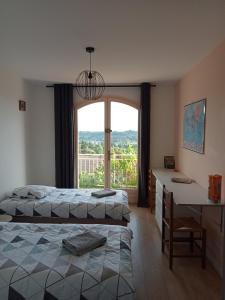 una camera con letto, scrivania e finestra di Vaste villa en position dominante superbe vue lacs a Hautecour