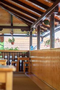 un restaurante con paredes de madera, mesa y sillas en Pensiunea Casa Ioana, en Şugag