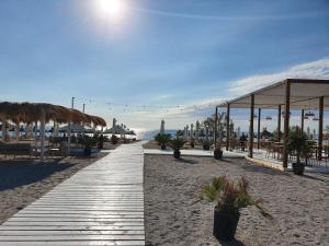 un camino por la playa con mesas y sombrillas en Sea On Exclusive Studios, en Mamaia
