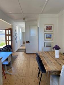 sala de estar con mesa de madera y sillas en Wine Coast Cottage, Port Willunga, en Port Willunga