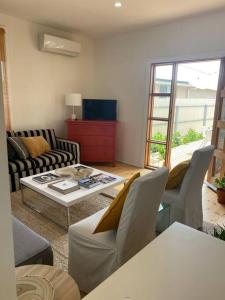 sala de estar con sofá y mesa en Wine Coast Cottage, Port Willunga, en Port Willunga