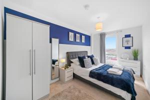 a bedroom with a blue accent wall and a bed at Stunning 2 Bedroom Apartment in Leeds