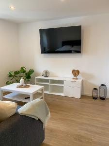ein Wohnzimmer mit einem Sofa und einem TV an der Wand in der Unterkunft Fewo Catlen in Traben-Trarbach