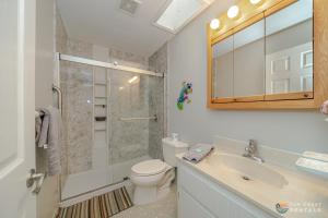 a bathroom with a toilet and a sink and a shower at Flagler Avenue adjacent Dog Friendly Home with Garage! Stroll to the Beach! in Chicken Island +17 photos