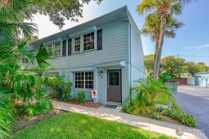 a blue house with a palm tree in front of it at Flagler Avenue adjacent Dog Friendly Home with Garage! Stroll to the Beach! in Chicken Island