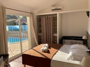 a bedroom with a bed with two teddy bears on it at Villas CALA CORSA 4 Chambres Piscine privée chauffée - Internet Fibre - Entièrement Climatisée à Lecci de Porto-Vecchio Cala Rossa in Lecci +36 photos