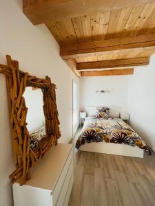オーバーニュにあるMaison de charme au pied du Garlabanのベッドルーム1室(鏡付きのベッド1台、木製の天井付)