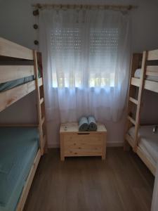 a bedroom with two bunk beds and a window at Casa cerca de Sevilla con piscina in Valencina de la Concepción