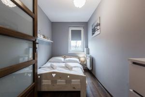 a small bedroom with a bed and a window at Apartament Świerkowy Potok Odkryj Zakopane in Zakopane