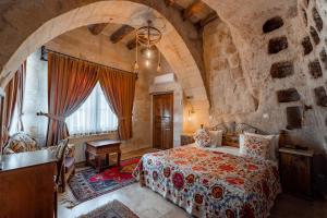 ein Schlafzimmer mit einem großen Bett in einem Steinzimmer in der Unterkunft Amber Cave Suites in Goreme