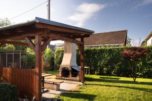 a wooden gazebo with a fireplace in a yard at Penzion Mona in Jeseník