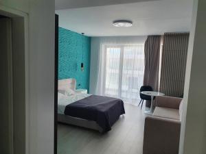 1 dormitorio con 1 cama, 1 silla y 1 ventana en Sea On Exclusive Studios, en Mamaia