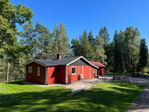eine kleine rote Kabine in der Mitte eines Gartens in der Unterkunft Asserbostugan in Överlida
