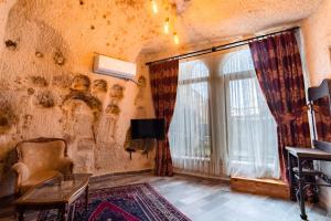 um quarto antigo com uma janela e uma cadeira em Amber Cave Suites em Goreme