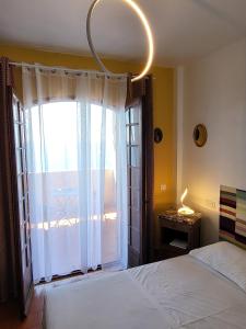 - une chambre avec un lit et une grande fenêtre dans l'établissement Soutariba, à Roquebrune-Cap-Martin