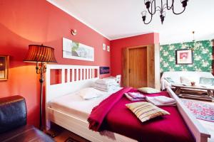 ホムトフにあるHotel Clochardの赤い壁のベッドルーム1室(大型ベッド1台付)