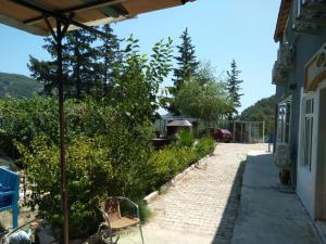 a walkway leading to a house with a bench at TOKGÖZ HOTEL RESTAURANT in Ulupinar