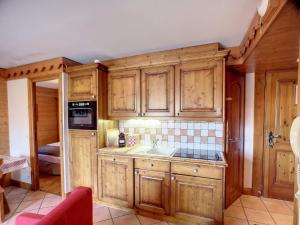 a kitchen with wooden cabinets and a sink at Appartement 3 Pièces à Reberty 2000 - 6 Pers, Piscine, Spa, Parking, Pieds des Pistes - FR-1-178-366 in Les Menuires