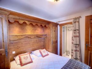a bedroom with a wooden headboard and a bed with two pillows at Appartement 3 Pièces à Reberty 2000 - 6 Pers, Piscine, Spa, Parking, Pieds des Pistes - FR-1-178-366 in Les Menuires