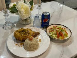 una mesa con un plato de comida y un tazón de arroz en Fakher Yanbu Hotel, en Yanbu