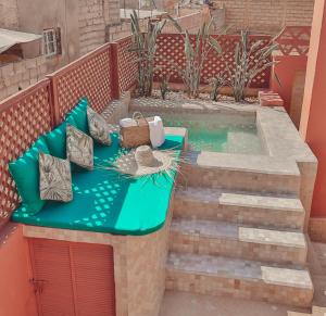 uma pequena piscina de mergulho num pátio com um sofá verde em Riad Le Limoun and Spa em Marrakech