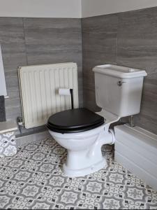 a bathroom with a white toilet with a black lid at 205a Monton Road in Manchester