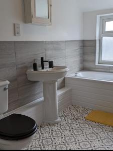 een badkamer met een wastafel, een toilet en een bad bij 205a Monton Road in Manchester