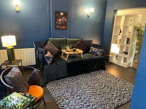 een woonkamer met een bank en een tafel bij Le Duplex du Beffroi in Douai