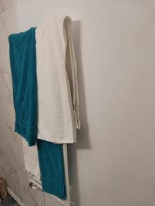 a pile of towels hanging on a rack in a bathroom at Bloom Box Apartments in Craiova